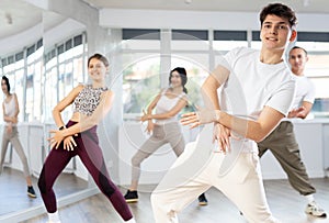 Guy with team of young like-minded people learn to dance modern dances