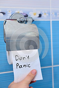 Guy tears off toilet paper with inscription Do not panic