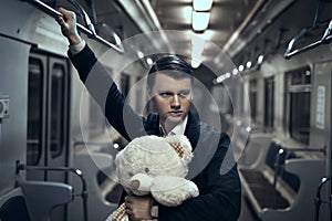 Guy with a teddy bear in the subway.