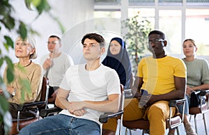 Guy teenager listens to lecture while sitting on chair