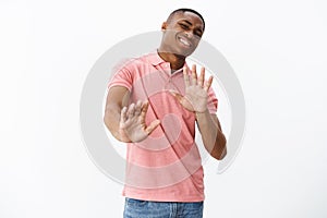 Guy think he pass. Uninterested african american man unwilling to participate in party raising hands near chest in no photo