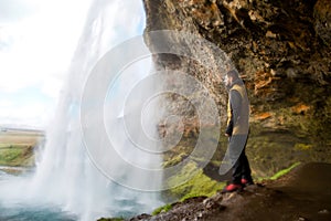 Guy tourist standing near waterfall enjoying the view