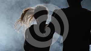 Guy trainer and the girl on the boxing. Light from behind. Silhouette . Smoke background. Slow motion