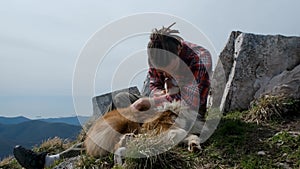 The guy is traveling with dog, an Australian Shepherd. Kisses and hugs the dog. Travel concept. Caucasian man with