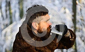 Guy with trees covered by snow on background. Brutal gamekeeper. photo