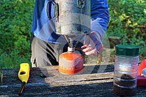 Guy turns on fuel under camp cooking pot