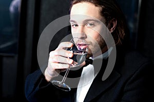 Guy in tuxedo drinking cocktail