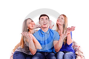 Guy and two girls sitting on the couch and looking up