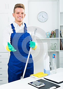 guy in uniform cleaning in office.