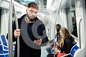 Guy using mobile phone in metro car