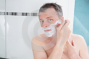 Guy using shaver in man bathroom