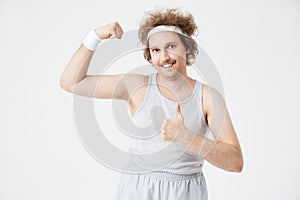 Guy in vest tucked into sport pants on grey background