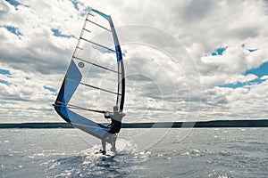 The guy in the waggon swims on the windsurf on lake