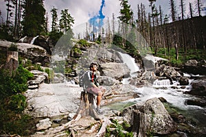 The guy was a tourist with sitting on a rock near the waterfall in Slovakia