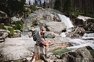 Ten chlap byl turista seděl na skále u vodopádu na Slovensku