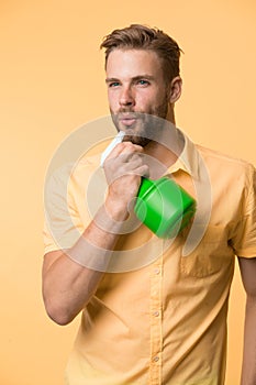 Guy with water spray in hand pretend blow smoke after shooting. Housework and sanitary concept. Care about moisturizing