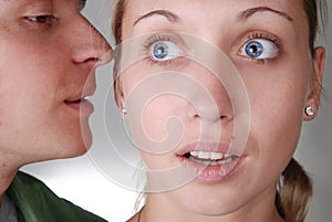 A guy whispering something to a girl