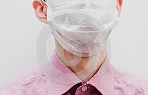 A guy in a white medical mask. In a pink shirt