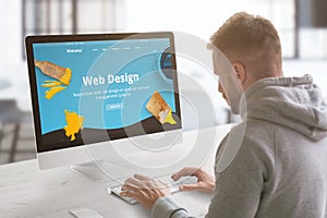 Guy work on modern web site on computer in graphic, web design studio office