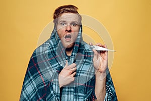Guy Wrapped in Plaid Pointing on Thermometer