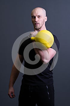 Guy with a yellow kettlebell gym anonymous workout strength, from fit teenager from picking from resitance youth