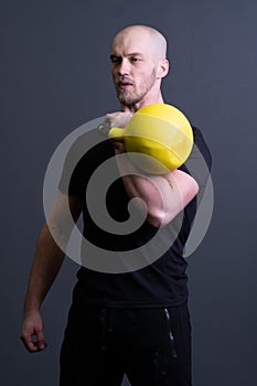 Guy with a yellow kettlebell gym anonymous young man, from fit effort from picking from rubber sportswear, vietnamese