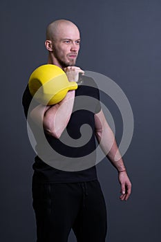 Guy with a yellow kettlebell gym anonymous young strength, for sporty lifestyle for strong and floor sportswear