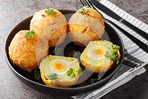 Guyanese cassava balls stuffed with boiled egg and then fried close up in a plate. Horizontal