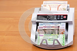 Guyanese dollars in a counting machine