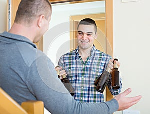 Guys with beer bottles at doorway