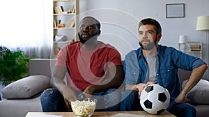 Guys frustrated by defeat of favourite team, watching football match on tv