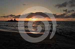 Guys taking photos while watching the sun setting over a beautiful ocean