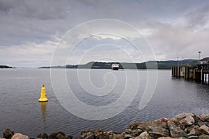 A ferry approaching a port on the coast of Scotland on a cold summers day.