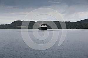 A ferry approaching a port on the coast of Scotland on a cold summers day.