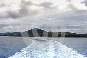 The wake left by a ferry travelling along the coast of Scotland on a cold summers day.