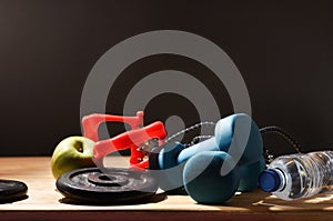 Gym accessories on wooden table and dark background
