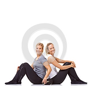Gym buddies. Two gym friends sitting back to back while isolated on a white background.