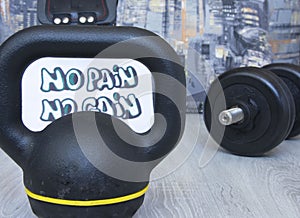 Gym dumbbell, kettlebell with motivational poster no pain no gain for active workouts at home. Home workouts