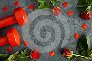 Gym dumbbells and red roses for Valentine\'s Day. Flat lay composition with copy space.