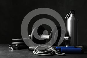 Gym equipment and accessories on floor against dark background