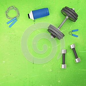 Gym fitness sport background. Flat lay template with weight dumbell, shaker, jumping rope isolated on blue background. Fit sport