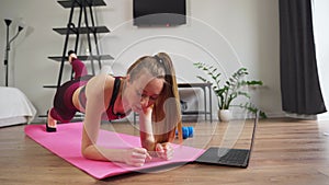 Gym girl at home. Young woman doing sport fitness training in sportswear in the room. Mat workout.