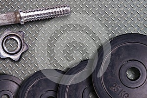 Gym hard dumbbell and weights. Stel sport equipment on metal gym floor background.