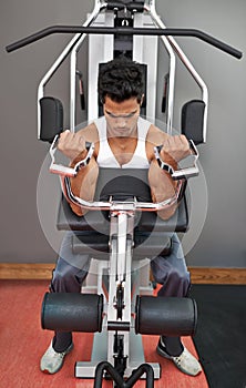 The gym is his sanctuary. Full-length shot of a young ethnic man exercising in the gym.