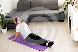 Gym at home. Active senior woman doing exercise at home, empty space