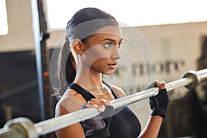 Gym, Indian woman or bodybuilder with barbell in fitness training, workout or exercise for body building. Strong girl