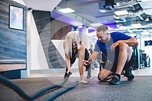 Gym instructor and a woman exercising at the gym.