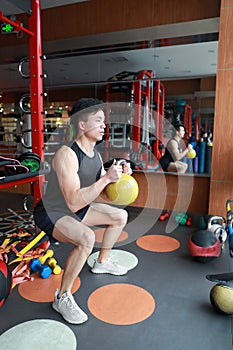 Gym man in gym working out using kettlebells indoor. Beautiful, press.