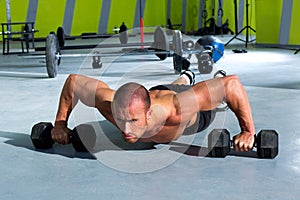 Gym man push-up strength pushup exercise with dumbbell