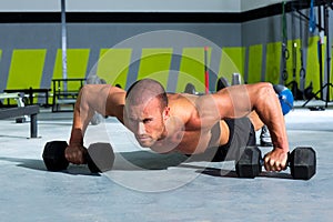 Gym man push-up strength pushup exercise with dumbbell